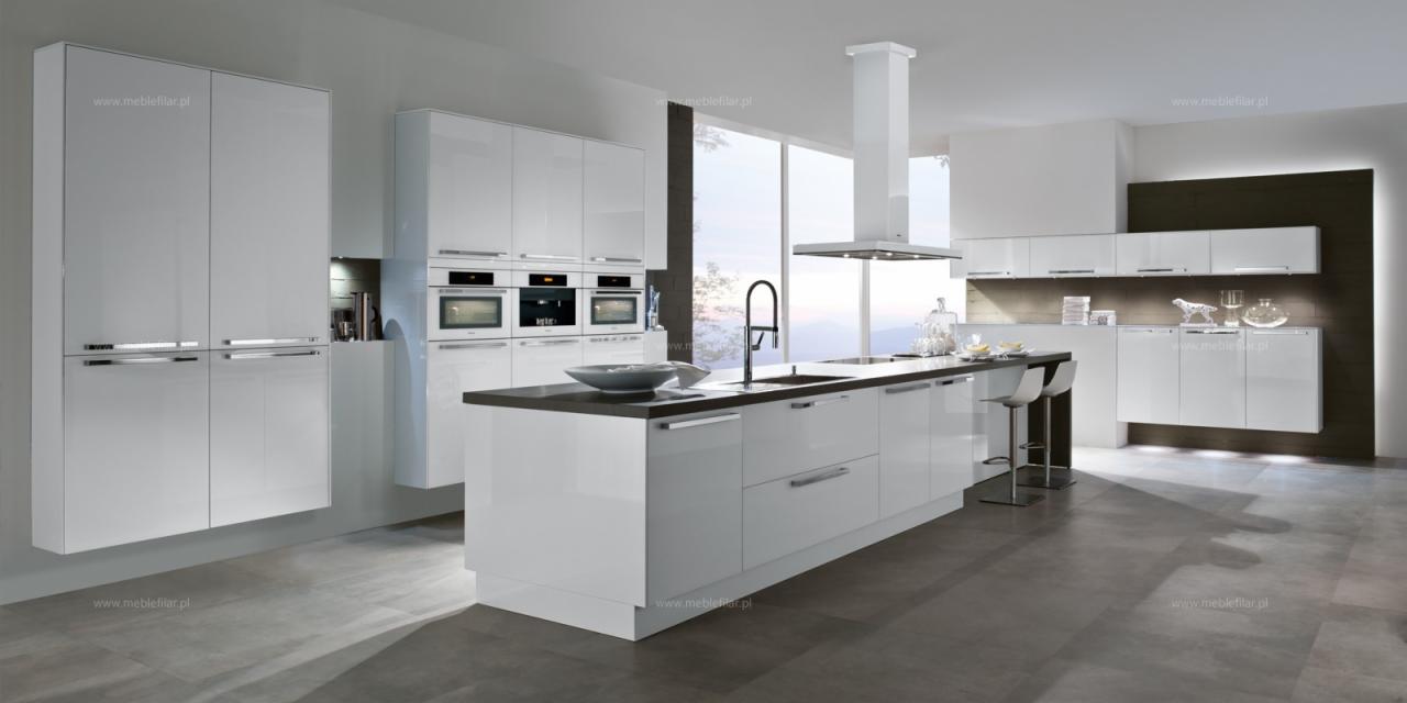 Nowoczesna, minimalistyczna kuchnia z białymi, lakierowanymi frontami, wyspą z ciemnym blatem i wbudowanymi sprzętami AGD, oświetlona naturalnym światłem z dużego okna.