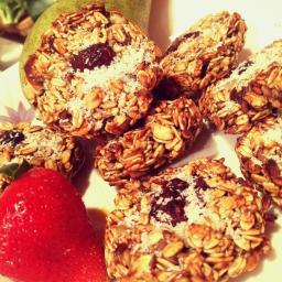 Dominika Malinowska - Owsiane ciasteczka z suszoną żurawiną i wiórkami kokosowymi na talerzu, obok świeża truskawka i gruszka.