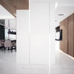 Nowoczesne wnętrze: białe ściany, marmurowa podłoga, drewniane akcenty na suficie i szafach, jadalnia z szarymi krzesłami i abstrakcyjny obraz na ścianie, widok na kuchnię z wbudowanym piekarnikiem.