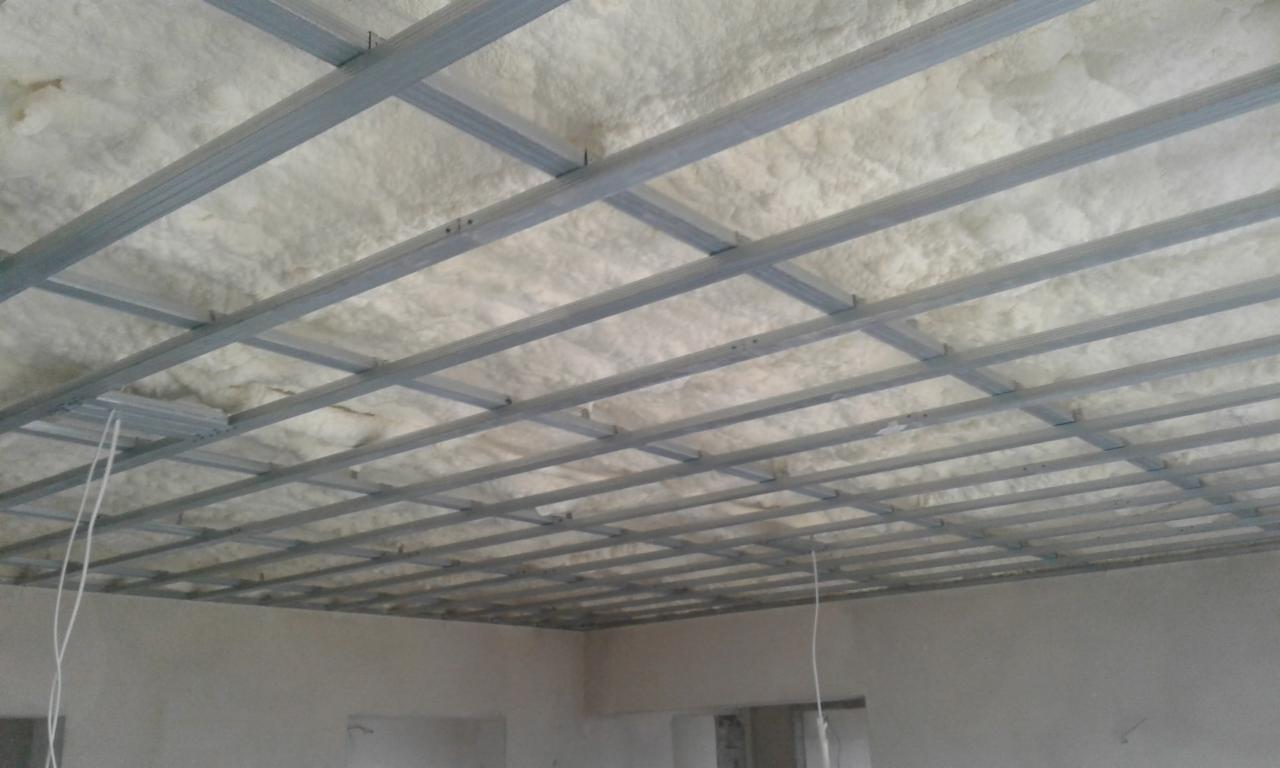 Montaż metalowej konstrukcji pod płytę karton gips na suficie z widoczną izolacją z pianki poliuretanowej.