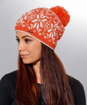 Portret kobiety w pomarańczowej czapce zimowej z białymi wzorami śnieżynek i pomponem, profil z długimi, brązowymi włosami.