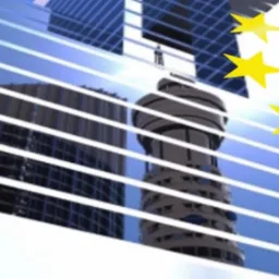 Szklana fasada biurowca odbija inne budynki, nałożony symbol gwiazd Unii Europejskiej, kompozycja w odcieniach błękitu i żółci.