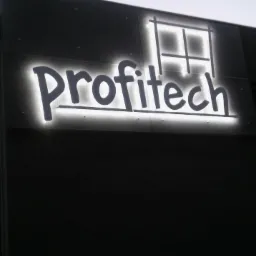 Elewacja budynku z podświetlanym szyldem 'Profitech' w kształcie okna.