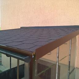 RO-STA Firma Ogólnobudowlana Starosta Roman - Wykończony daszek nad wejściem w Obrzycku, pokryty brązowym gontem bitumicznym w kształcie rybiej łuski, z nową, brązową obróbką blacharską i orynnowaniem.