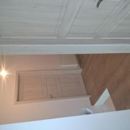 RO-STA Firma Ogólnobudowlana Starosta Roman - Widok na fragment wnętrza po remoncie: zamontowane drzwi wewnętrzne z ościeżnicą w kolorze jasnego drewna, panel podłogowy w odcieniach brązu, pomalowane ściany na jasny kolor, widoczny grzejnik.