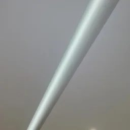 Gładka, biała listwa sufitowa LED zamontowana ukośnie na jasnoszarym suficie z pojedynczym, okrągłym halogenem w prawym dolnym rogu.