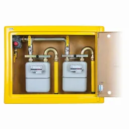 Dwa gazomierze w żółtej, otwartej szafce, połączone rurami z zaworami, widoczne liczniki i elementy instalacji gazowej.