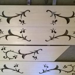 PPHU Wolski - Cztery drewniane parapety z wyciętymi dekoracyjnymi wzorami roślinnymi, ułożone jeden na drugim, z widoczną strukturą drewna.