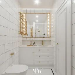 Biała łazienka z kwadratowymi płytkami, złotą armaturą i lustrem z oświetleniem w stylu garderoby teatralnej, widoczny fragment toalety.