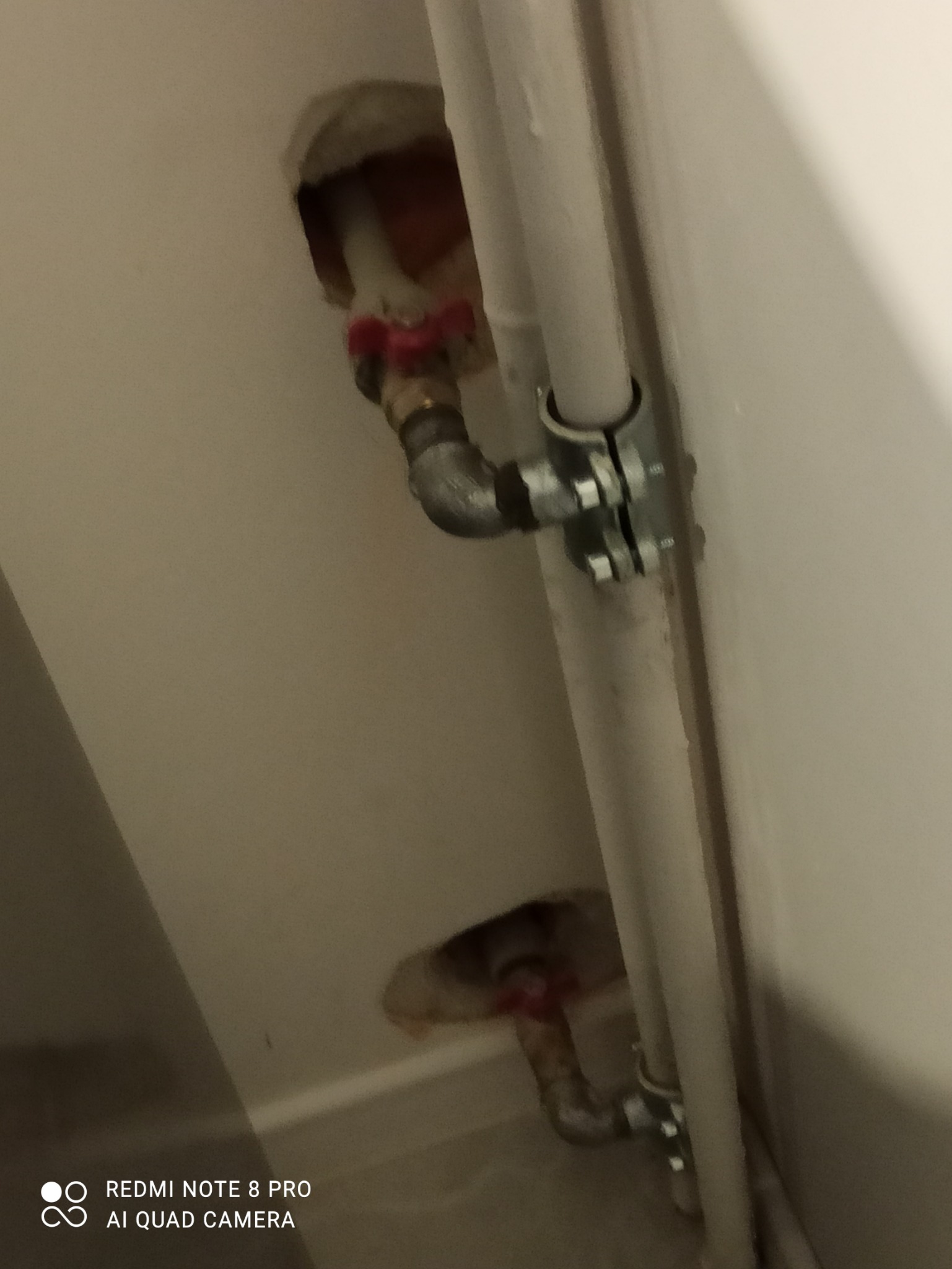 Rury kanalizacyjne z zaworami wystające ze ściany w trakcie prac instalacyjnych.