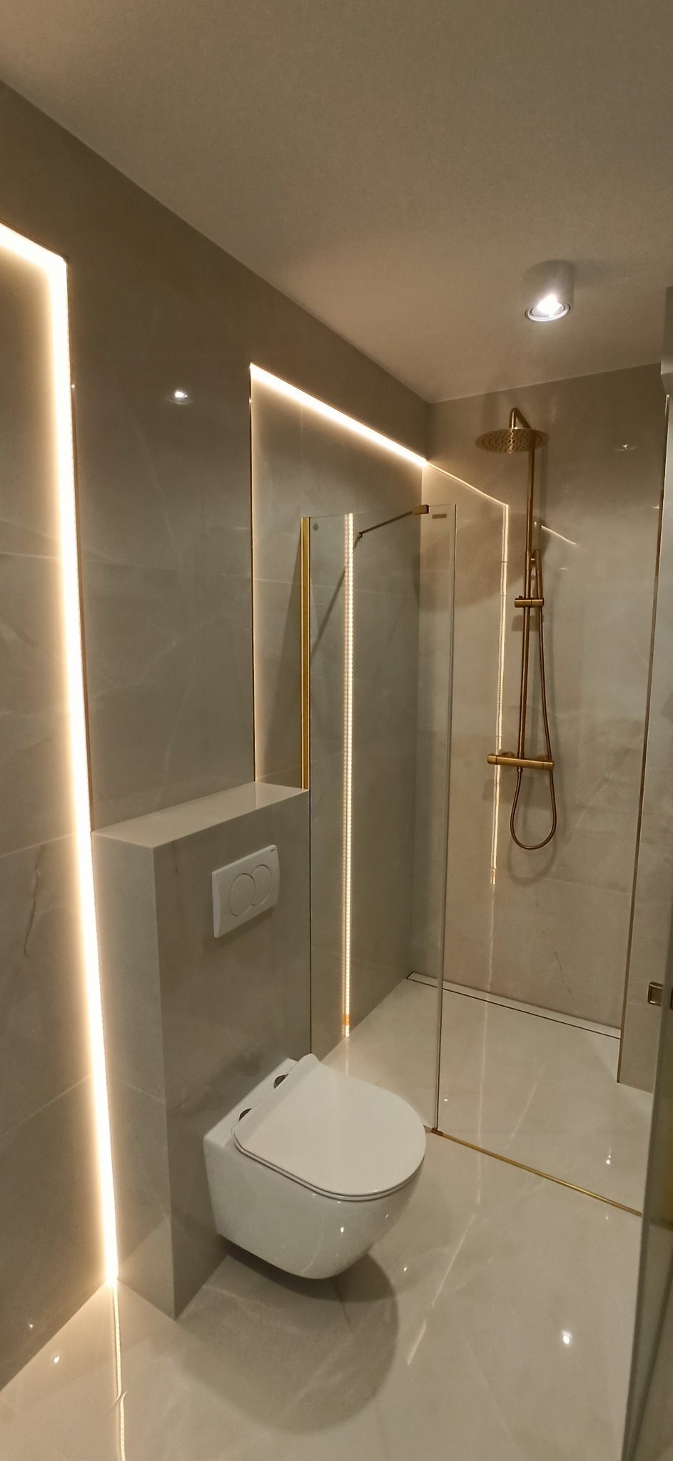 Nowoczesna łazienka w Miechucinie z podświetlanymi panelami ściennymi, kabiną prysznicową ze złotymi elementami i podwieszaną toaletą.