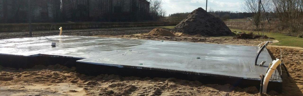 Wylany fundament pod dom murowany w Nowogrodźcu, widoczne izolacje i przygotowane przyłącza.