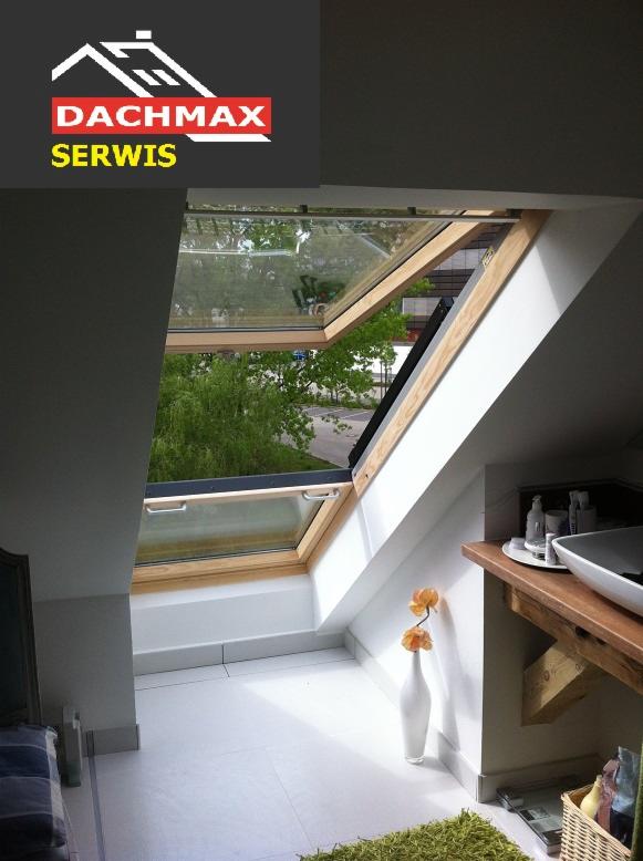 Otwarty drewniany okno dachowe z widokiem na zieleń, jasne wnętrze z umywalką na drewnianym blacie, biały wazon z pomarańczowymi kwiatami i dywanik z długim włosiem.