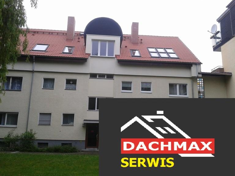 Budynek mieszkalny z czerwonym dachem i oknami dachowymi, zasłonięty w dolnej części logotypem firmy Dachmax Serwis.