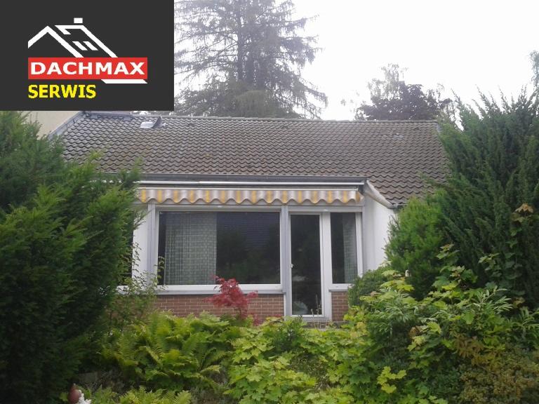 Dom jednorodzinny z szarym dachem, widoczne okna z markizą w biało-żółte pasy, przysłonięte częściowo przez bujną roślinność, w lewym górnym rogu logo firmy Dachmax Serwis.