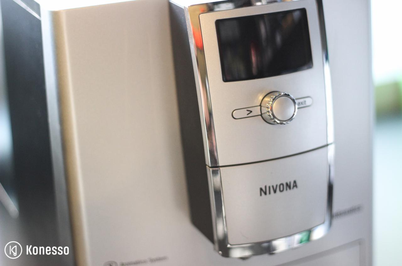 Szczegółowy widok panelu sterowania ekspresu Nivona w srebrnej obudowie, z chromowanymi detalami i pokrętłem wyboru funkcji.