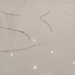 Biała posadzka żywiczna z ciemniejszymi, nieregularnymi wzorami przypominającymi marmur, widoczna w rogu pomieszczenia z białymi ścianami i gniazdkami elektrycznymi.