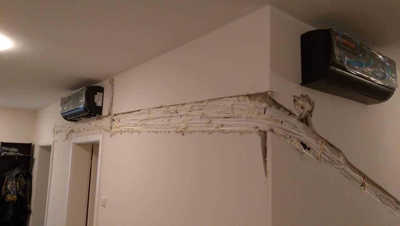 Montaż trzech jednostek wewnętrznych z przewodami w pianie montażowej biegnącymi wzdłuż ściany pod sufitem w trakcie instalacji.