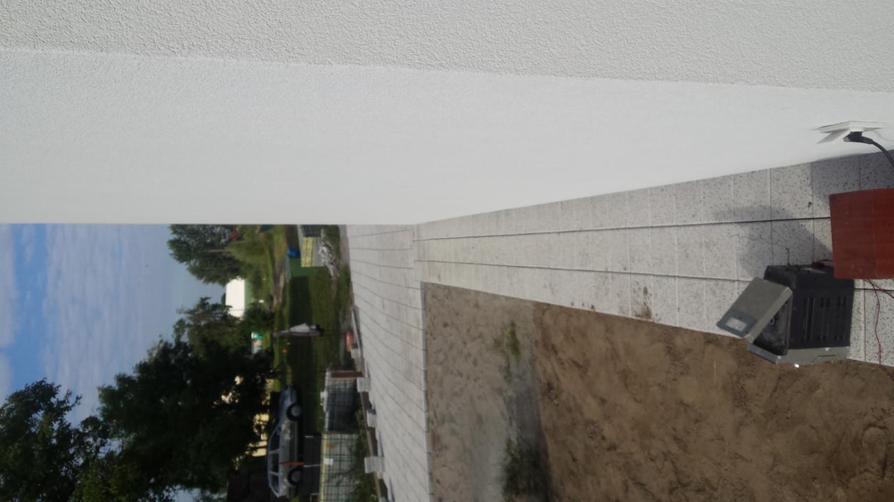 Niedokończona powierzchnia wyłożona jasną kostką brukową w Borówcu, widoczny fragment ziemi i zaparkowany samochód w tle, ujęcie z niskiej perspektywy.