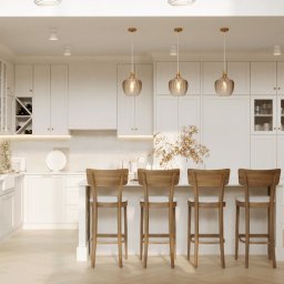 Projekt44 Dorota Kanawka - Jasna kuchnia w stylu klasycznym: białe szafki, drewniane hokery przy wyspie, złote lampy wiszące. Parkiet w jodełkę, subtelne oświetlenie LED.