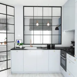 Nowoczesna kuchnia z białymi szafkami, czarnym blatem i przeszklonymi ściankami działowymi w stylu industrialnym; widoczne elementy dekoracyjne i oświetlenie punktowe.