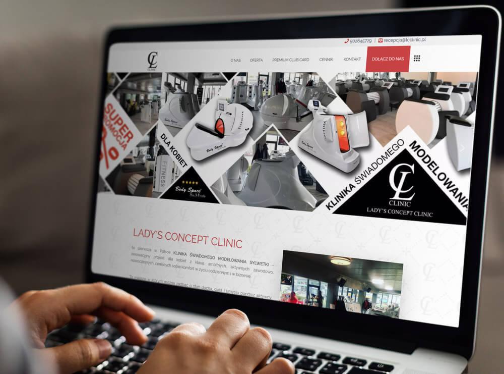Ekran laptopa z wyświetloną stroną internetową kliniki modelowania sylwetki Lady's Concept Clinic, prezentującą urządzenia do modelowania ciała.