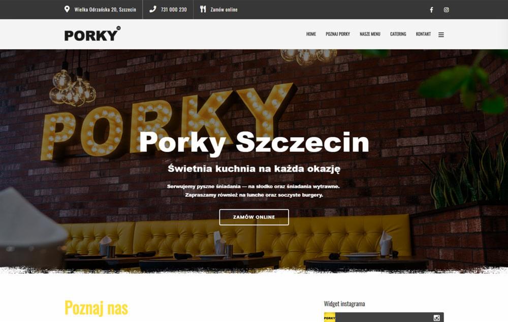 Strona internetowa restauracji w Katowicach prezentująca wystrój wnętrza z ceglaną ścianą i podświetlanym logo 'Porky'.