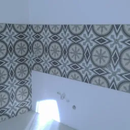 Fragment ściany z ułożonymi dekoracyjnymi płytkami w odcieniach szarości i bieli, widoczne otwory na instalacje