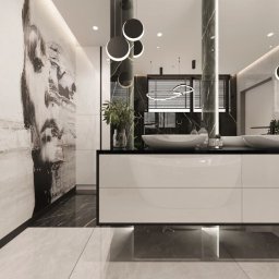archdesign Agnieszka Romańczyk - Nowoczesna łazienka w Szczecinie z marmurową ścianą akcentującą, podwieszaną szafką z umywalkami i okrągłymi lampami. Minimalistyczny design z roślinami.