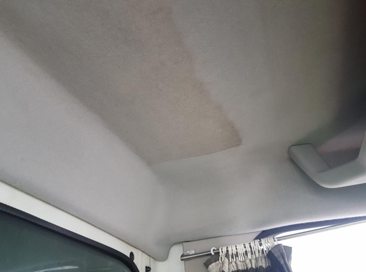 Brudna, szara podsufitka samochodu dostawczego z widocznym, ciemniejszym śladem po zabrudzeniu przed czyszczeniem.