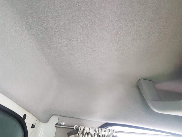 Jasnoszara podsufitka samochodu dostawczego z uchwytem, widok z wnętrza pojazdu.