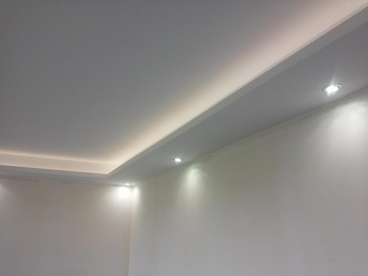 Nowoczesny sufit podwieszany z oświetleniem LED punktowym i listwami LED, ściany przygotowane do malowania.