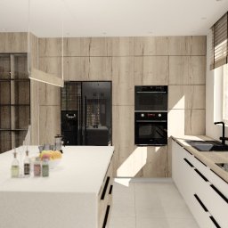 IZA ROJSZA - Nowoczesna kuchnia z dużą wyspą, drewnianymi frontami szafek i czarnymi akcentami, takimi jak piekarnik i lodówka side-by-side, oświetlona wiszącą lampą.