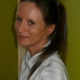 Portret uśmiechniętej brunetki w koszuli w paski na tle limonkowo-zielonej ściany.