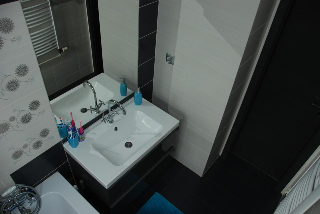 Nowoczesna łazienka z dwoma umywalkami nablatowymi, armaturą chromowaną, biało-czarnymi płytkami i akcentami w kolorze niebieskim, widok z góry.