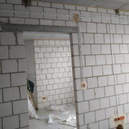 EL-BOL, Usługi Elektryczne, Smart Home - Surowy stan wnętrza z widocznymi kablami elektrycznymi prowadzonymi po ścianach z betonu komórkowego, instalacja podtynkowa w trakcie realizacji.