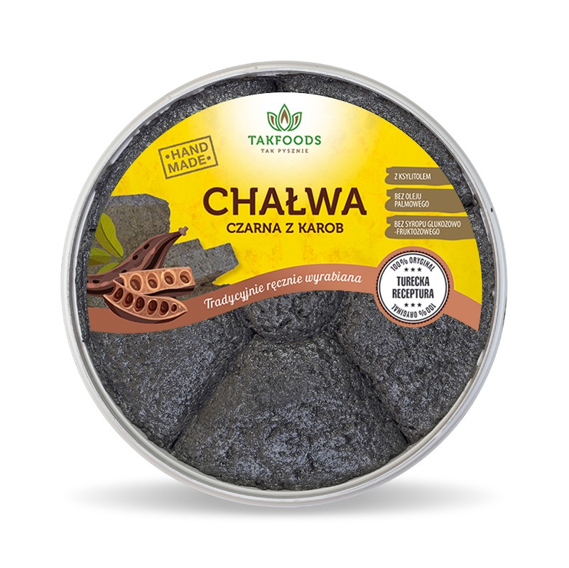 Czarna chałwa z karobem w przezroczystym opakowaniu, z widocznymi informacjami o składzie i ręcznym wyrobie, na żółto-brązowym tle etykiety z logo TAKFOODS.