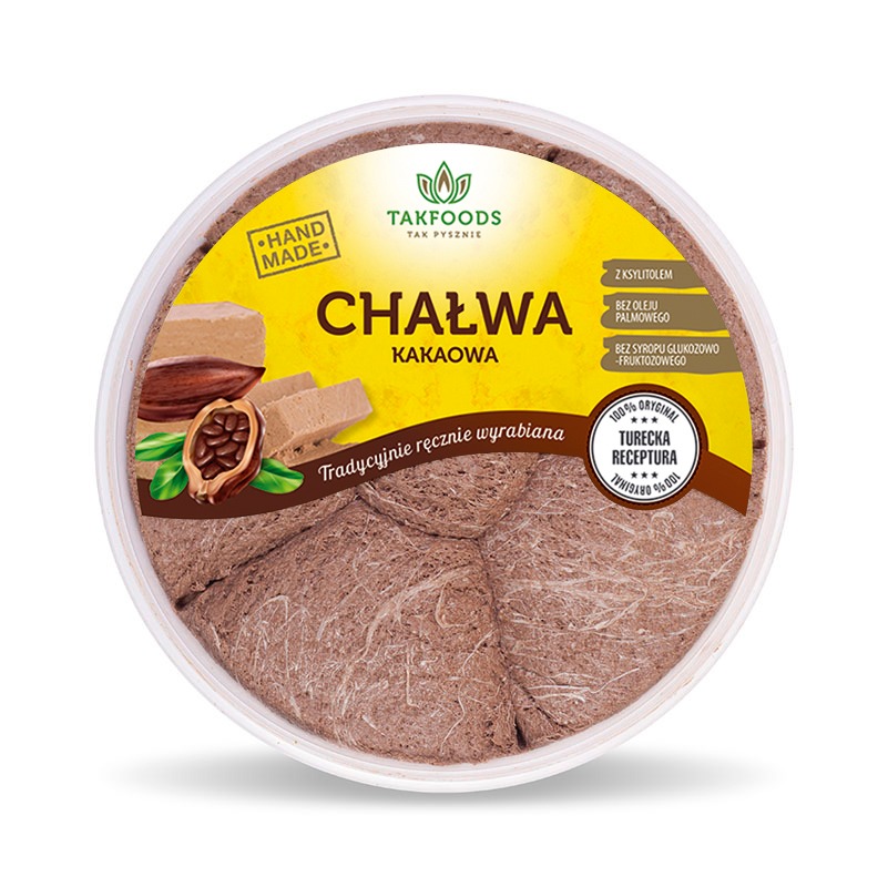 Okrągłe opakowanie chałwy kakaowej marki Takfoods, z etykietą informującą o ręcznym wyrobie, użyciu ksylitolu i braku oleju palmowego oraz syropu glukozowo-fruktozowego; widoczne kostki chałwy...