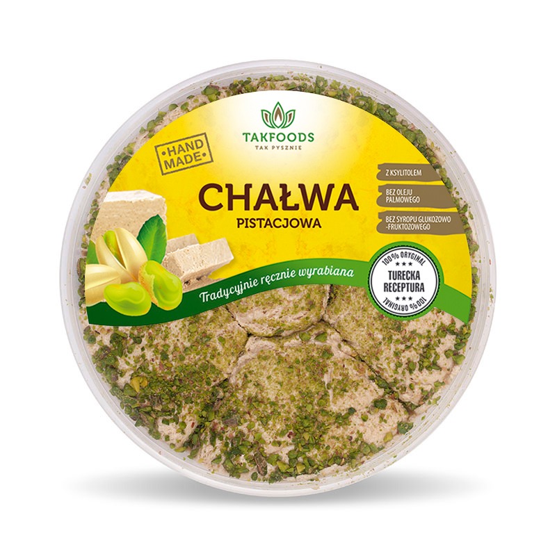 Okrągłe opakowanie chałwy pistacjowej z etykietą informującą o ręcznym wyrobie i składnikach, widoczne pistacje i kawałki chałwy.