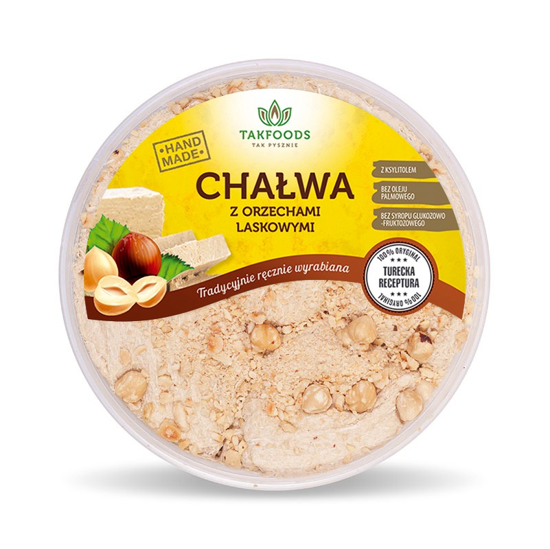 Okrągłe opakowanie chałwy z orzechami laskowymi marki Takfoods, z informacją o ręcznym wyrobie i braku oleju palmowego oraz syropu glukozowo-fruktozowego, widoczne orzechy laskowe i kawałki chałwy.