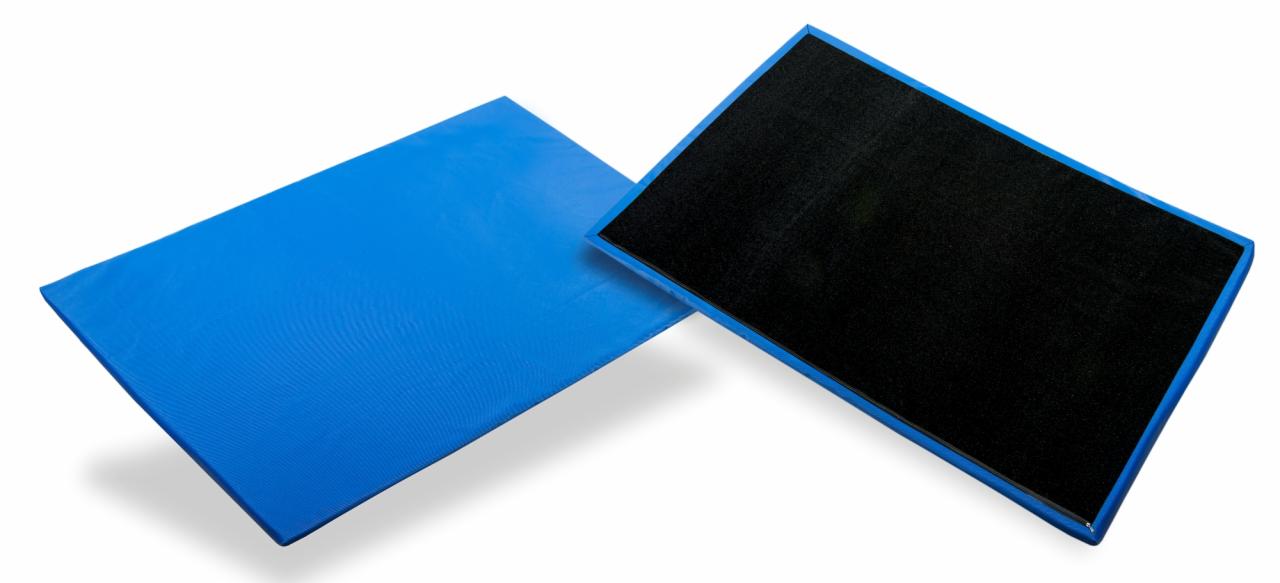 Dwie prostokątne maty: niebieska z teksturowaną powierzchnią i czarna z niebieską ramką, leżące ukośnie na białym tle.