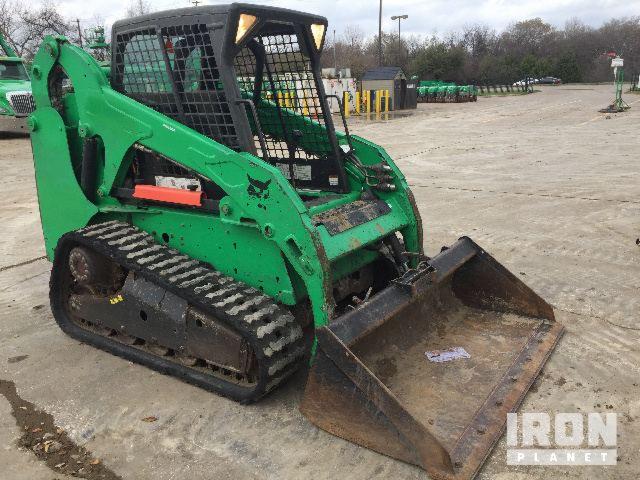 Zielona ładowarka gąsienicowa Bobcat z łyżką, stojąca na betonowym placu, widoczny znak wodny IronPlanet.