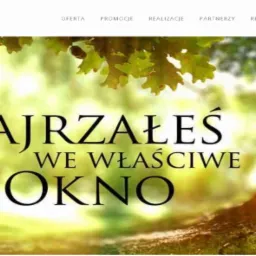 Grafika reklamowa firmy Artel z hasłem 'Zajrzałeś we właściwe okno', umieszczona na tle drzewa i zieleni.