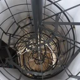 Wewnętrzny widok spiralnych, metalowych schodów w szybie, z perspektywy od dołu, ukazujący skomplikowaną konstrukcję i spawane łączenia elementów.