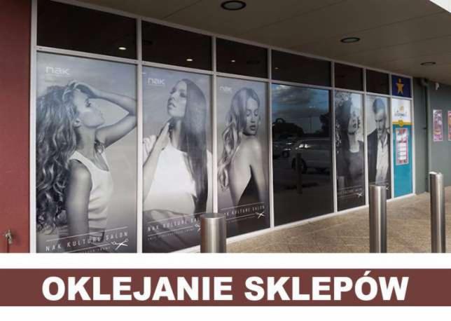 Okna salonu fryzjerskiego oklejone folią z grafiką czarno-białych portretów modelek z logo salonu.