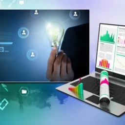 Koncepcja biznesowa: Ręka trzymająca żarówkę na tle ekranu z danymi, obok laptop z wykresami i zwinięty dokument z kolorowymi akcentami.
