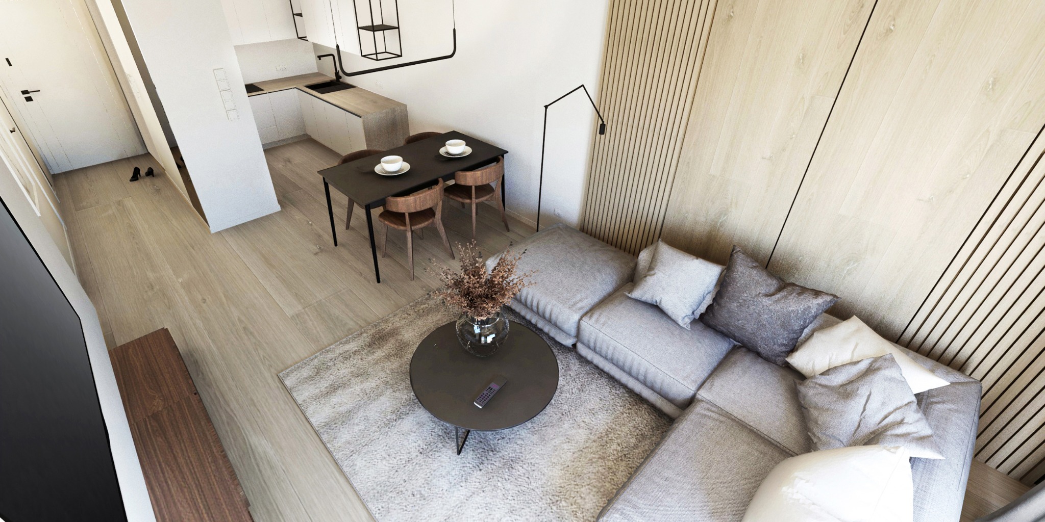 Wnętrze mieszkania z perspektywy z góry: minimalistyczna kuchnia, stół jadalny dla czterech osób, szara sofa modułowa z poduszkami, okrągły stolik kawowy z wazonem i pilotem, drewniana boazeria...