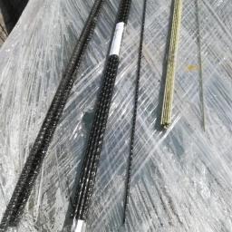 TechFlow3D - Różne rodzaje prętów zbrojeniowych, w tym kompozytowe i stalowe, leżące na folii ochronnej.