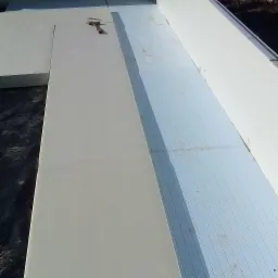 Izolacja fundamentów styropianem w trakcie prac, widoczne płyty EPS i XPS oraz narzędzia.