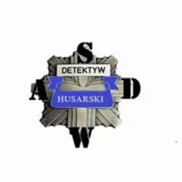 Metalowa odznaka z napisem 'Detektyw Husarski' na białym tle.